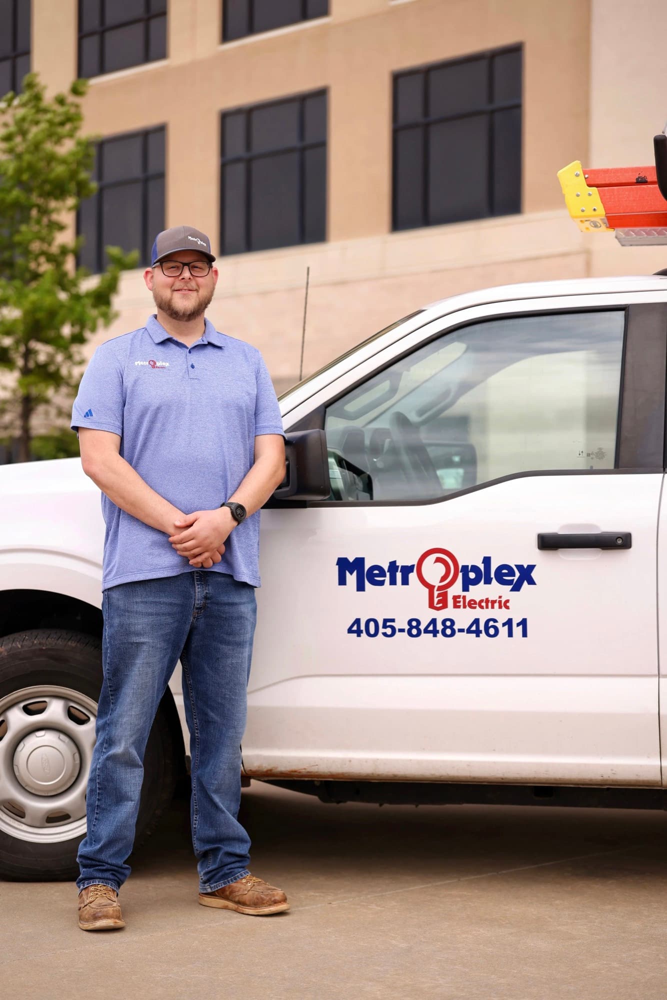 A Metroplex technician standing beside a company service truck in Oklahoma City
